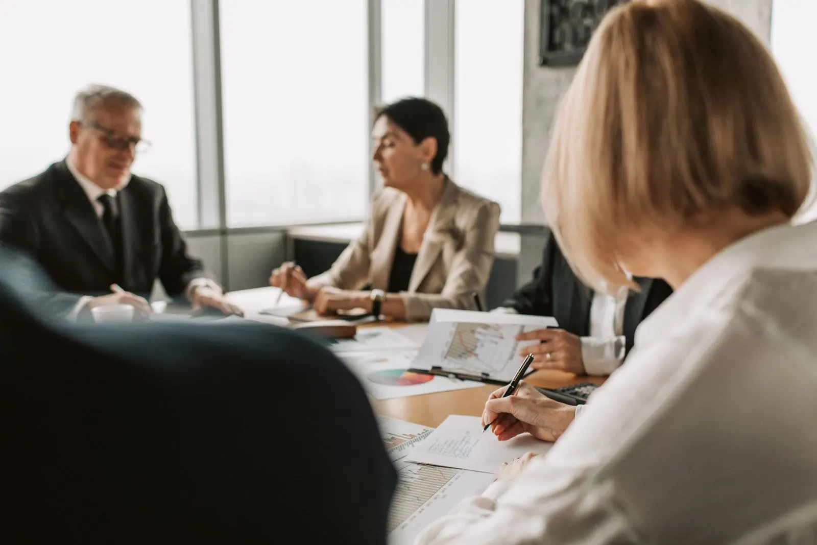 Trustees and their auditor reviewing financial reports at a meeting table