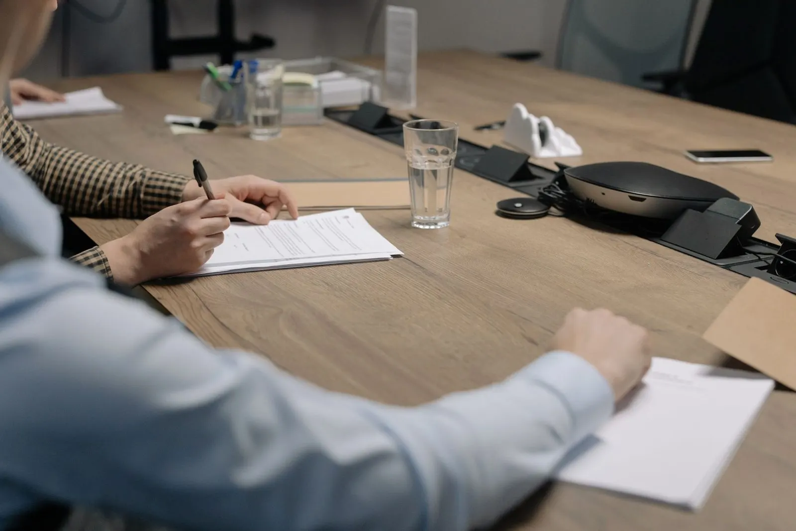 Directors signing papers at a boardroom table
