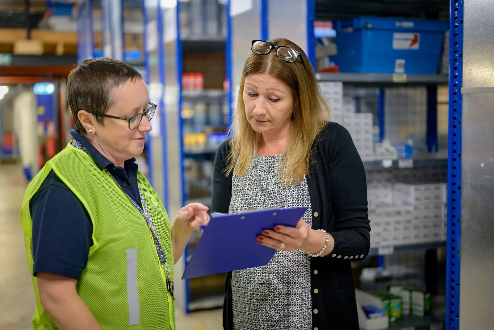 A stock count in progress in a warehouse, with a colleague checking a count sheet